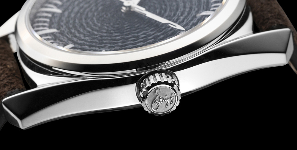 Case profile and crown of the CORNELY watch against black, engraved with the Ercigoj signature