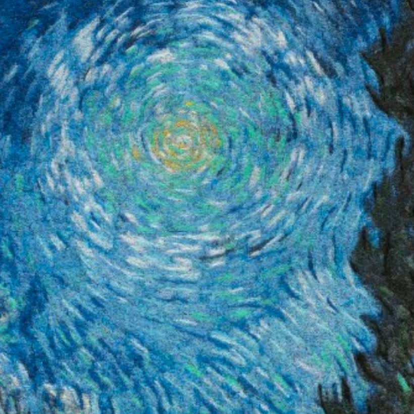 Ultra close-up of the swirling star in the embroidered Van Gogh, individual chenille stitches raised in blue, green and gold thread