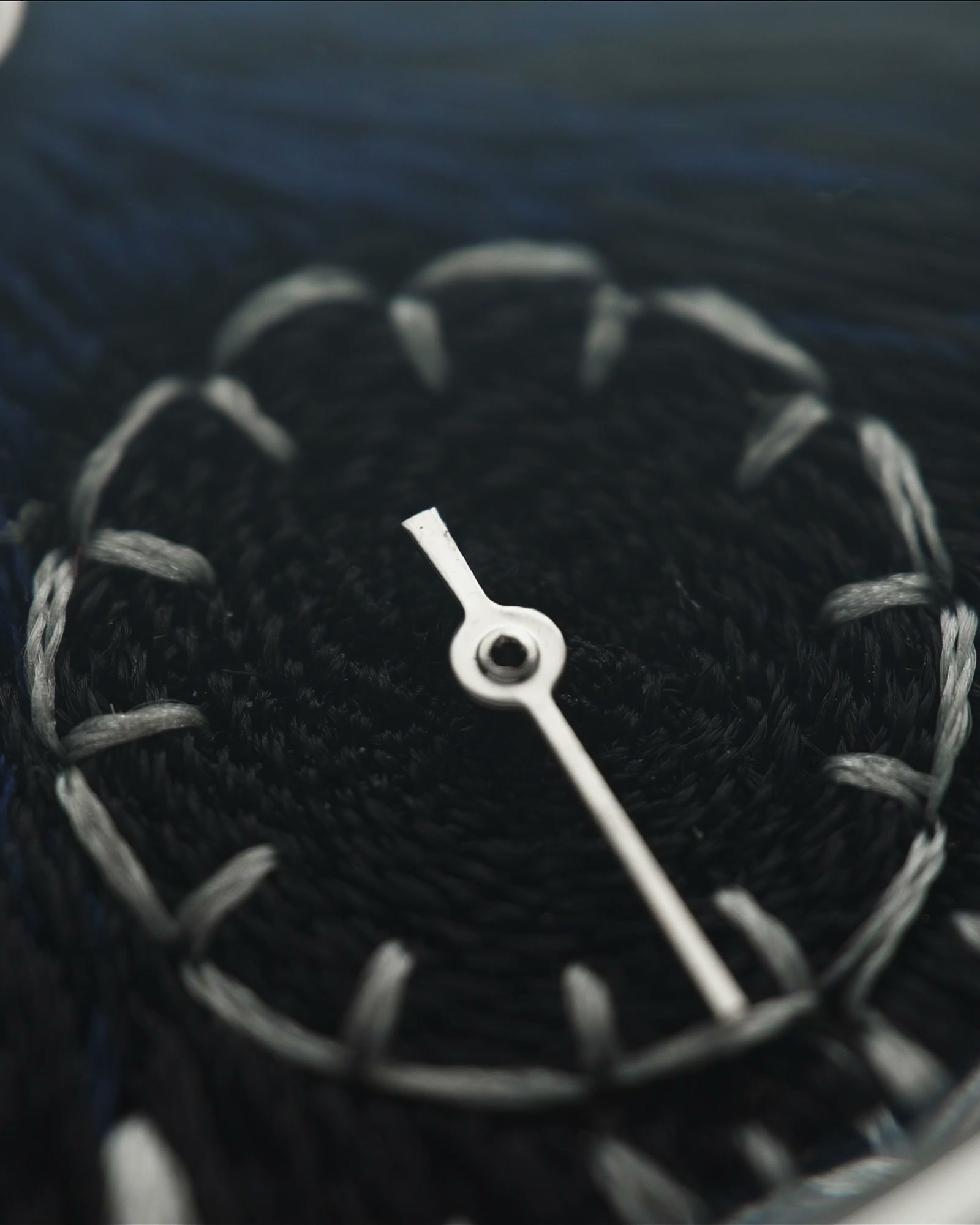JACKART's small seconds sub-dial, stitched indices in silver-grey thread against near-black chenille