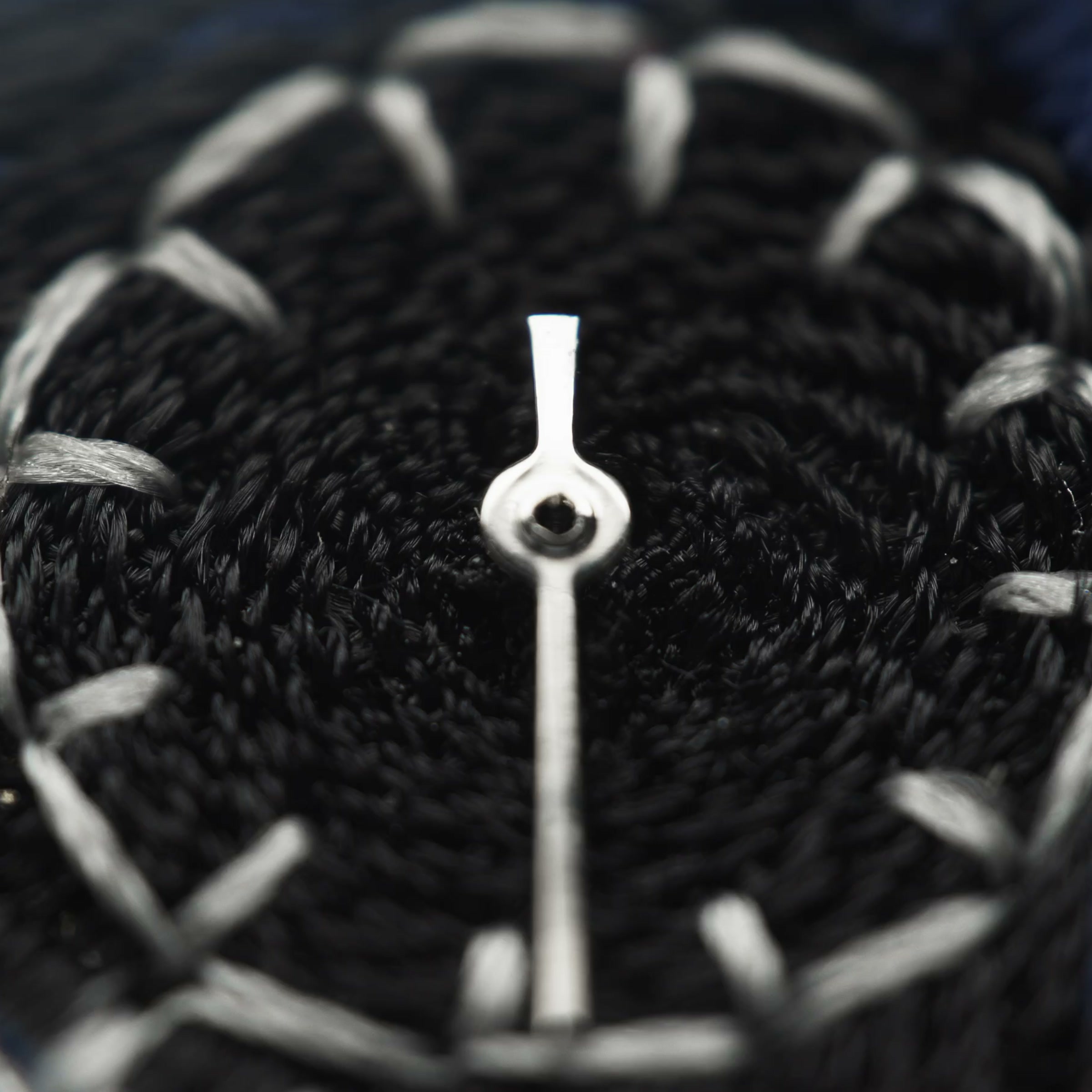 Extreme macro of JACKART's small seconds sub-dial, chenille loops in silver-grey thread against a near-black ground